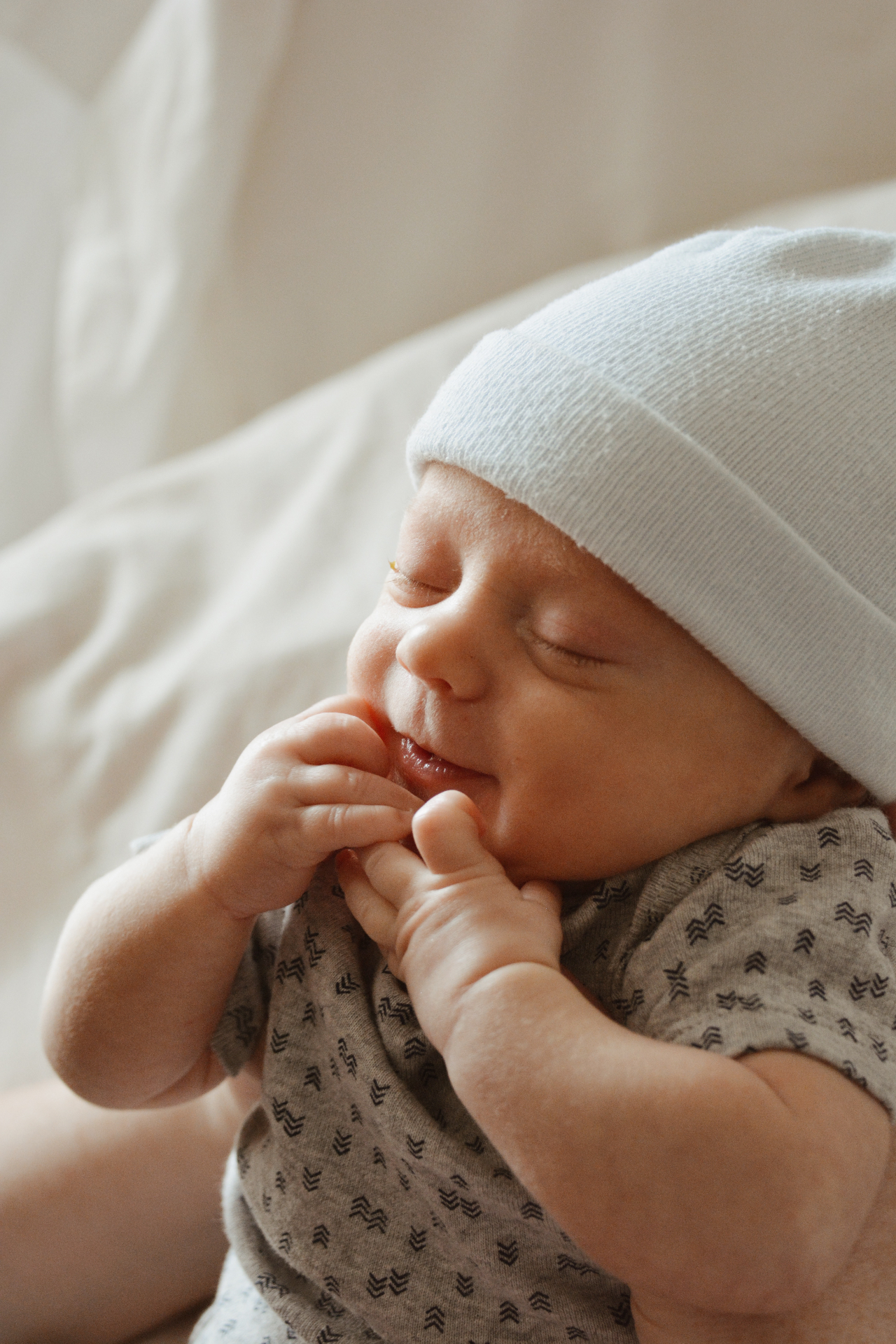 Sleeping newborn baby in a white knit hat