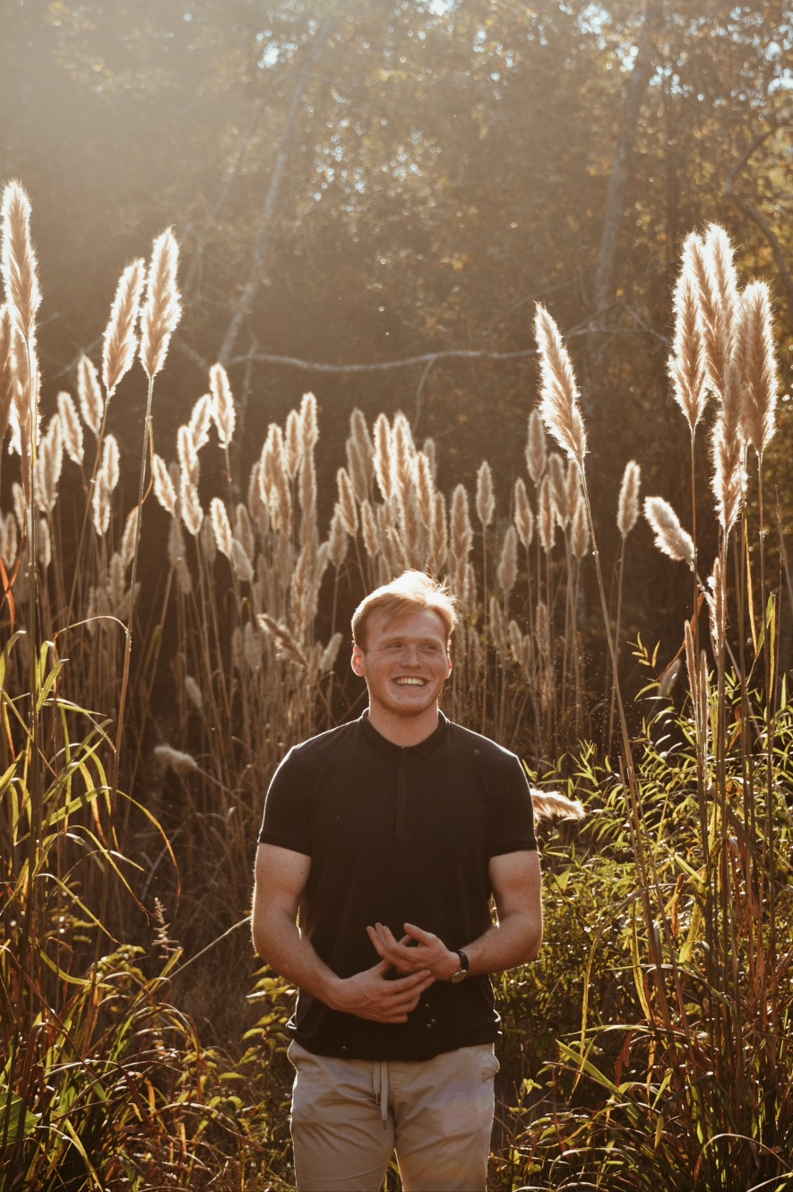 Young man laughing in golden hour pampas grass